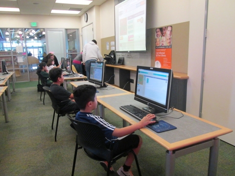 Nens i nenes treballant amb ordinadors