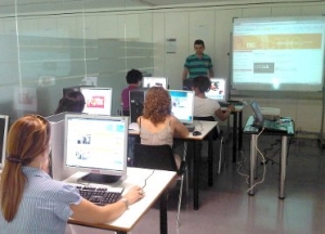 Imatge de la classe amb ordinadors i projector al fons